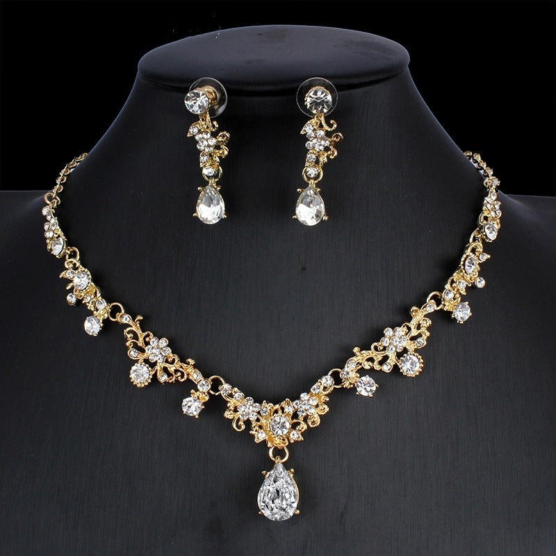 Gold necklace and earrings set on a black mannequin