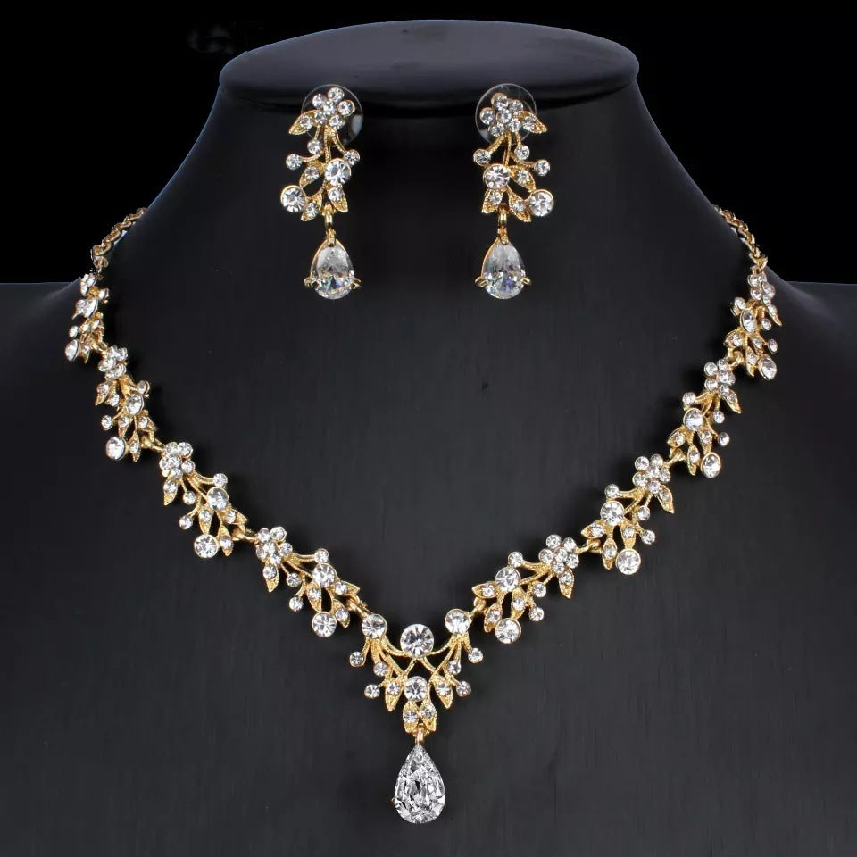Gold necklace and earrings set on a black background