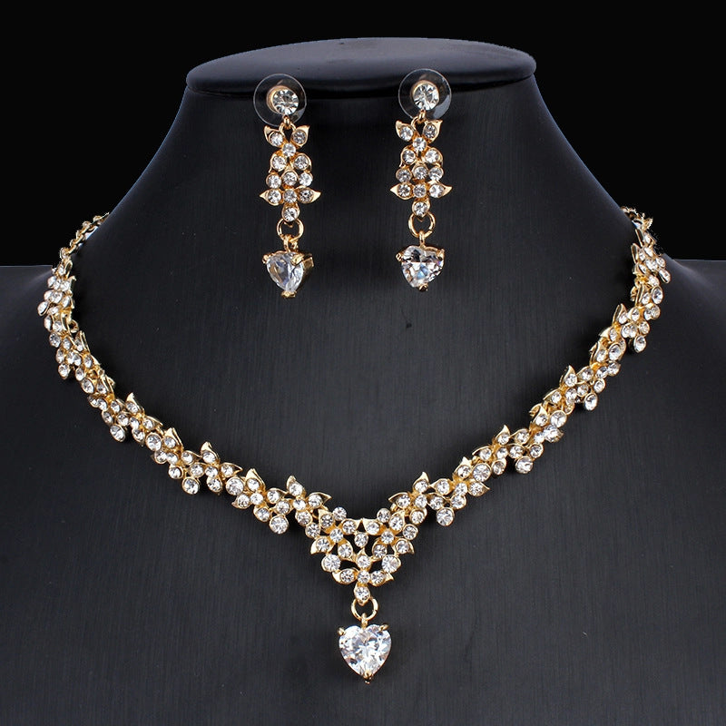 Gold necklace and earrings set on a black mannequin
