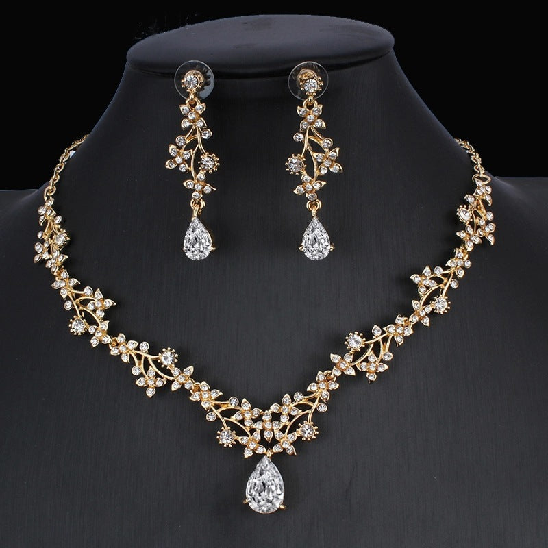 Gold necklace and earrings set on a black background