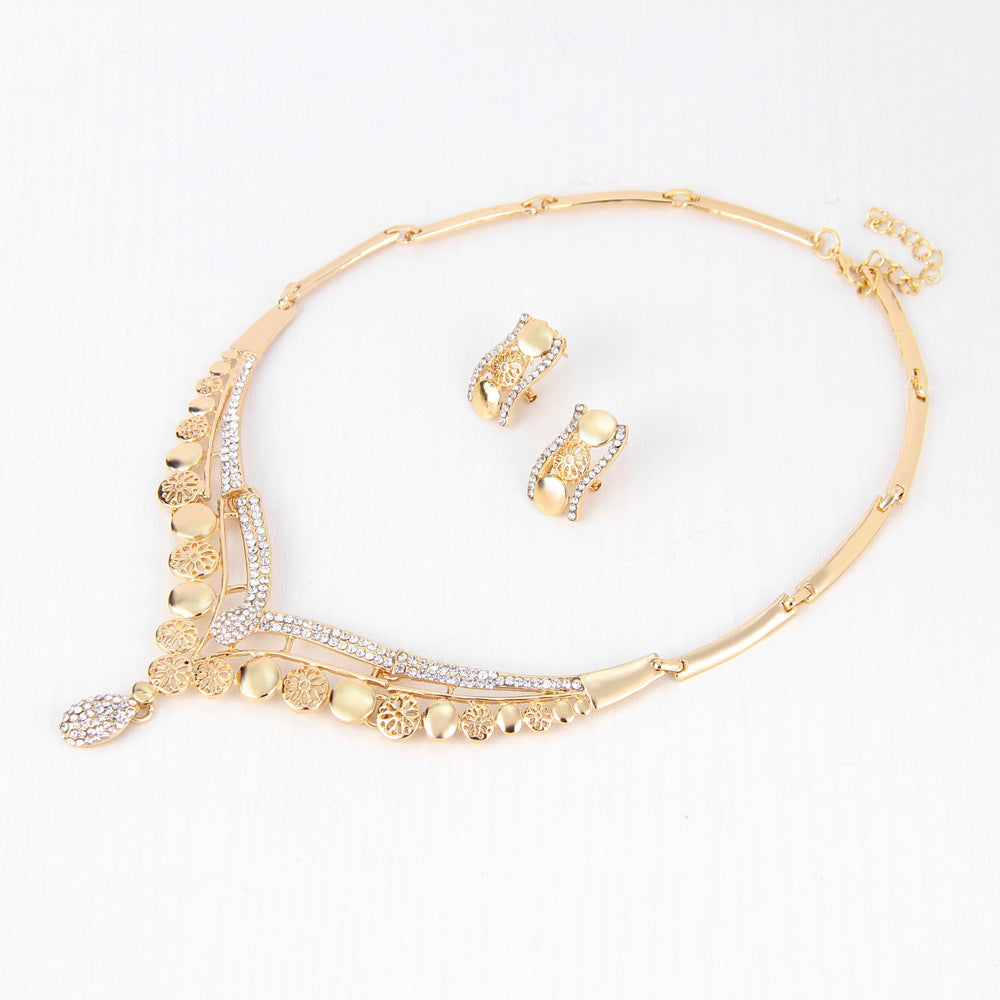 Gold necklace and earrings set on a white background