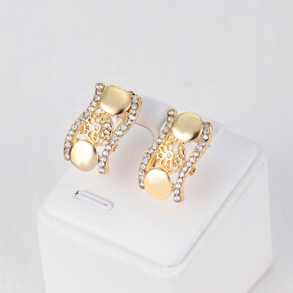 Gold earrings with intricate designs on a white background
